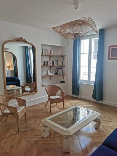 - un salon avec une table, des chaises et un miroir dans l'établissement La voûte de Jeanne, à Orléans
