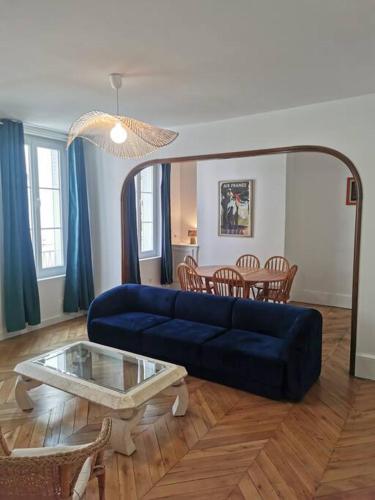 un salon avec un canapé bleu et une table dans l'établissement La voûte de Jeanne, à Orléans