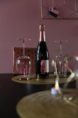 une bouteille de vin et deux verres sur une table dans l'établissement Superbe appartement avec Balnéothérapie/spa/ Champagne, à Pornic