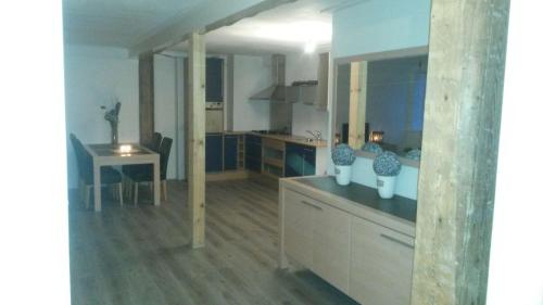 a room with a kitchen with a counter and a table at Apartment Vredehof in Sint Maartensbrug