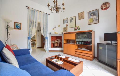a living room with a blue couch and a tv at Gorgeous Home In Piano Di Mommio in Piano di Mommio