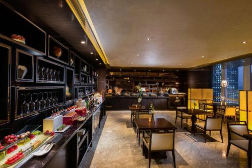 a restaurant with tables and chairs and a bar at Hilton Shenzhen Futian, Metro Station at Hotel Front Door, Close to Futian Convention & Exhibition Center in Shenzhen