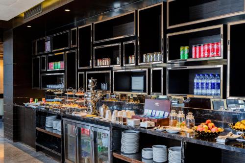 a restaurant with a bar with food and drinks at Hilton Shenzhen Futian, Metro Station at Hotel Front Door, Close to Futian Convention & Exhibition Center in Shenzhen