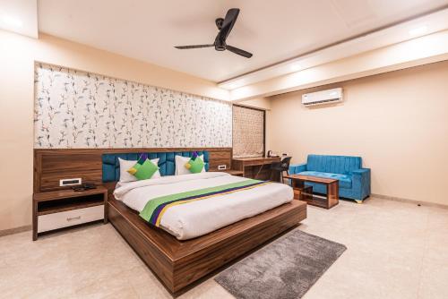 a bedroom with a bed and a blue chair at Lemon wood suites in Pune