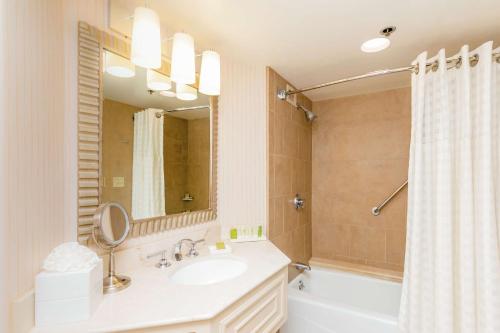 a bathroom with a sink and a tub and a mirror at Hilton Parc 55 San Francisco Union Square in San Francisco