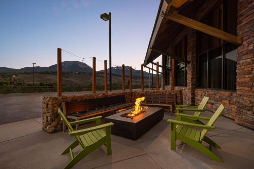 a patio with two green chairs and a fire pit at Hampton Inn & Suites Silverthorne in Silverthorne