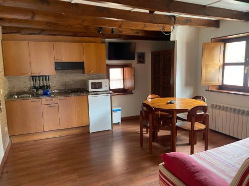 una cucina con un tavolo e una sala da pranzo di Apartamentos el Cueto de los Collado a Villanueva de Pría