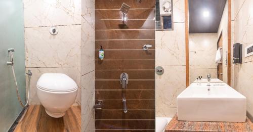 a bathroom with a toilet and a sink at Lemon wood suites in Pune