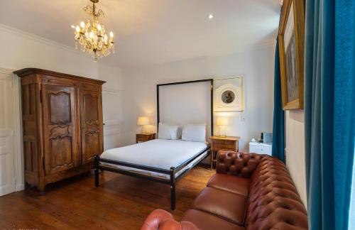 a bedroom with a bed and a couch at Suite Petite -Nice - SPA-JACUZZI - MASSAGE- SAUNA - 4 SAISONS - Piscine Chauffée Toute l'année - POOL VIEW- Heated Pool 800m city centre Nyons in Nyons