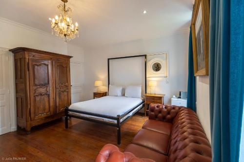 a bedroom with a bed and a couch at Suite Petite -Nice - SPA-JACUZZI - MASSAGE- SAUNA - 4 SAISONS - Piscine Chauffée Toute l'année - POOL VIEW- Heated Pool 800m city centre Nyons in Nyons
