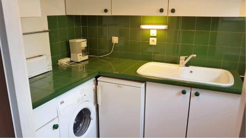 - une cuisine carrelée de vert avec un évier et un lave-linge dans l'établissement Secteur des Capellans pavillon avec vue sur la marina - 6MARINA25, à Saint Cyprien Plage