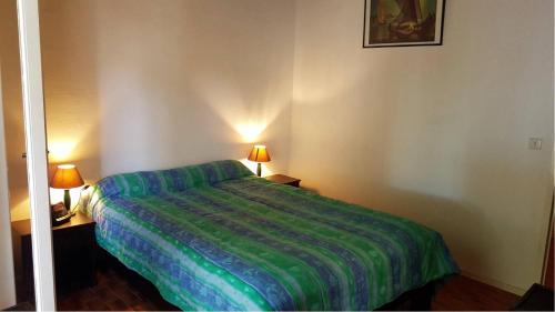 une chambre avec un lit avec une couverture verte dans l'établissement Secteur des Capellans pavillon avec vue sur la marina - 6MARINA25, à Saint Cyprien Plage