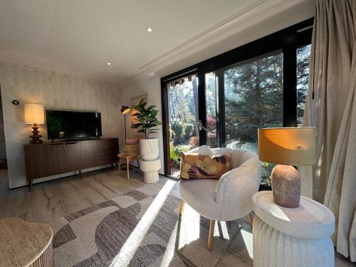 a living room with a couch and a tv at StayatSas Tiny House Pippa in de bossen op de Veluwe in Doornspijk