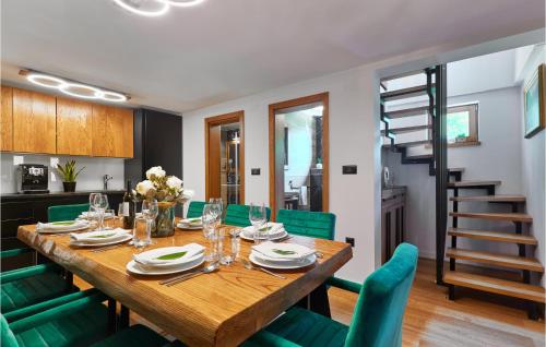 a dining room with a wooden table and green chairs at Lovely Home In Donja Stubica in Donja Stubica