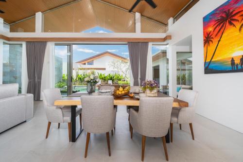 a dining room with a table and chairs at Villa private swimming pool and garden in Phuket Town