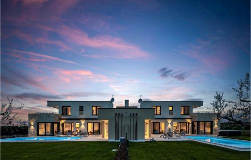 a large house with a pool at dusk at Villa Primavera in Brtonigla
