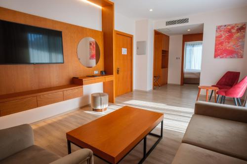 a living room with a couch and a tv at Caddem Inn Hotel in Mağusa