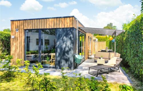 a tiny house in the garden with a patio at 2 Bedroom Cozy Home In Heinkenszand in Heinkensand