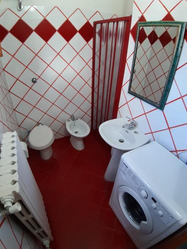 a bathroom with two toilets and a sink and a washing machine at casa tata fino a 6 posti letto in Roccaraso