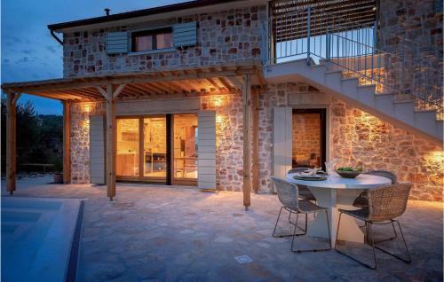 un patio di una casa con tavolo e sedie di Villa Arte a Stari Grad (Cittavecchia)