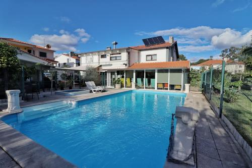 a swimming pool in front of a house at Hostel Jardins de São Luís in Setúbal