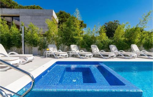 una piscina con sedie a sdraio e una piscina di Villa Mariner a Medulin