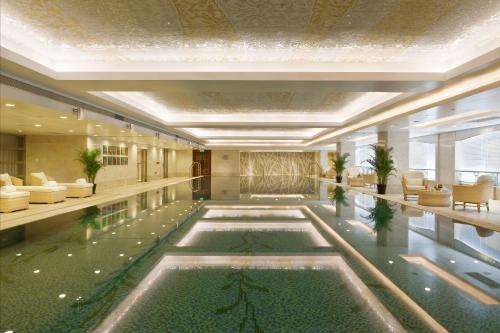 a hotel lobby with a pool in the middle at The Dragon Hotel Hangzhou in Hangzhou