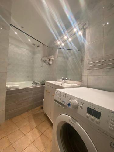 - un lave-linge dans la salle de bains pourvue d'un lavabo et d'une baignoire dans l'établissement Appartement proche de la gare, à Montpellier