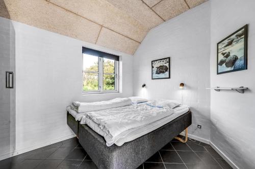 a bedroom with a bed in a room with a window at Beautiful Holiday Home With Spa And Sauna, Close To The North Sea And The Center Of Søndervig in Ringkøbing