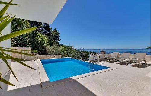 a pool with chairs and a view of the ocean at Villa Prestige in Baška Voda
