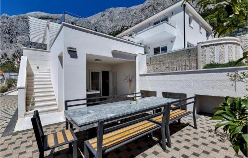 a patio with a table and benches in front of a house at Villa Prestige in Baška Voda