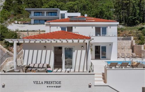 a white house with two chairs on the balcony at Villa Prestige in Baška Voda