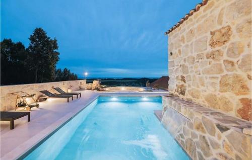 einen Pool mit Bänken neben einer Steinmauer in der Unterkunft Villa Mediterranean Estate in Uskoplje