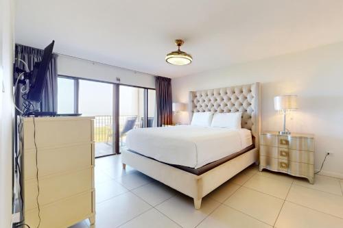 a bedroom with a large bed and a large window at Ocean Vista Condominiums #407 in South Padre Island