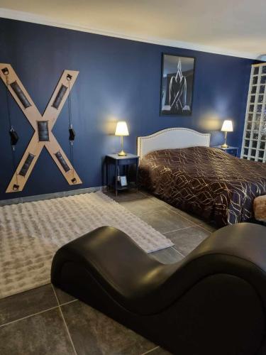 - une chambre avec un lit king-size et une chaise noire dans l'établissement Love Room La Volupté Spa Privatif, à Bétheniville
