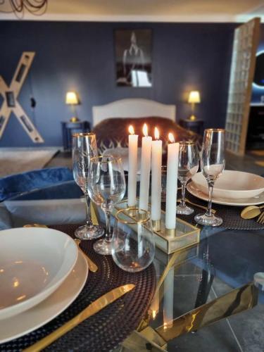 - une table avec des verres à vin et des bougies dans l'établissement Love Room La Volupté Spa Privatif, à Bétheniville