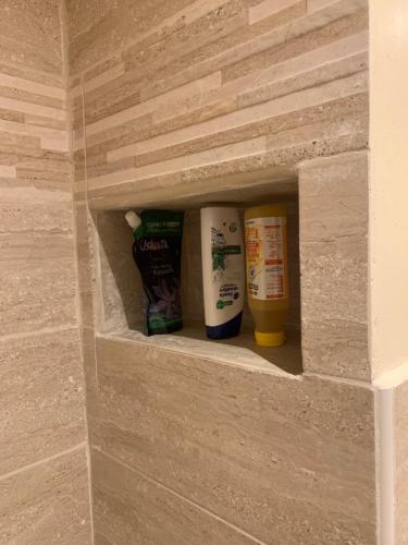 a shelf in a bathroom with toiletries in it at Un peu de campagne in Saint-Gilles-de-la-Neuville