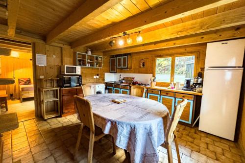 kuchnia ze stołem i białą lodówką w obiekcie Authentic family chalet with garden in Chamonix w Chamonix-Mont-Blanc