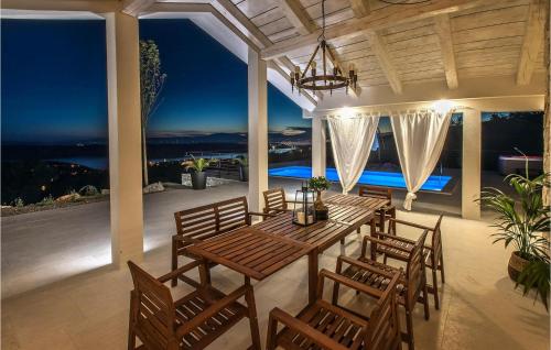 ein Esszimmer mit einem Tisch und Stühlen auf einer Terrasse in der Unterkunft Villa Belvedere in Jadranovo