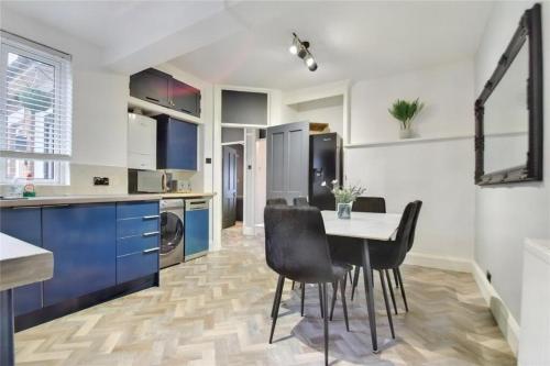 a kitchen with a table and chairs in a room at Manse Apartment in Great Malvern
