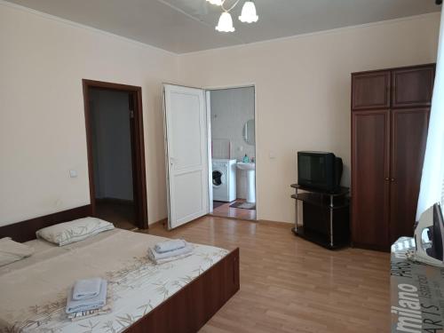 a bedroom with a bed and a television in it at Apartments Domovik on Beregovskaya 3 in Mukacheve