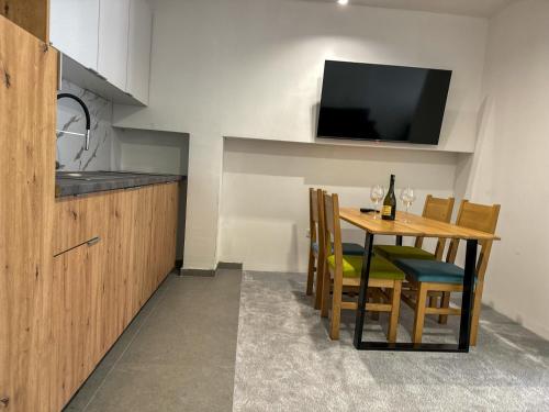 a kitchen with a table with chairs and a television at Aparthotel Jahorinski Konaci in Jahorina