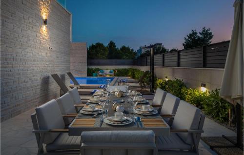 a long dining table and chairs on a patio at Villa Quentin in Vodice