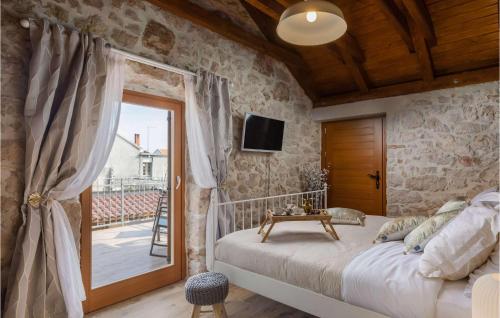 a bedroom with a bed and a balcony with a television at Villa Kameni Dvori in Sveti Filip i Jakov