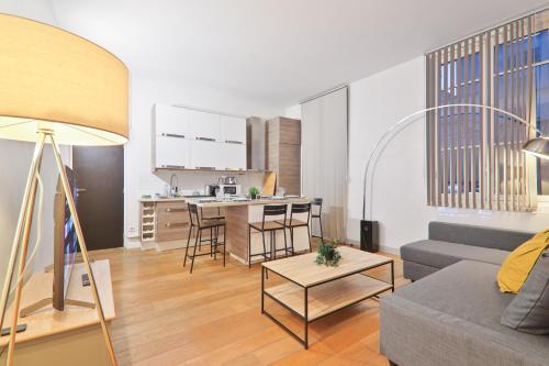 un salon avec un canapé et une table dans l'établissement Appartement Quartier Palais Garnier Free Netflix, à Paris