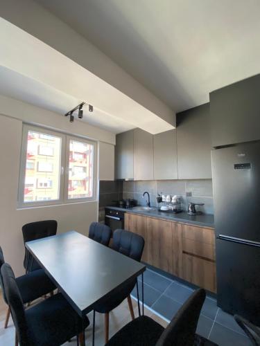 una cucina con tavolo, sedie e frigorifero di Solution for your needs! a Skopje