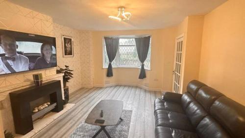 a living room with a couch and a flat screen tv at A Home away from Home in Birmingham