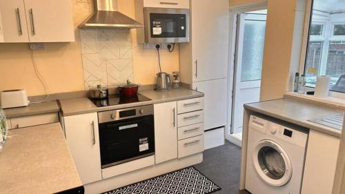 a kitchen with a washer and a washing machine at A Home away from Home in Birmingham