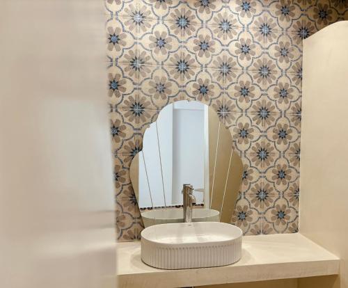 une salle de bains avec un lavabo et un miroir dans l'établissement Álas Holiday Home, à Archangelos