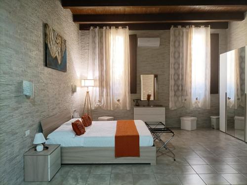 a bedroom with a large bed and a mirror at Domos La Corte Ghibellina in Iglesias